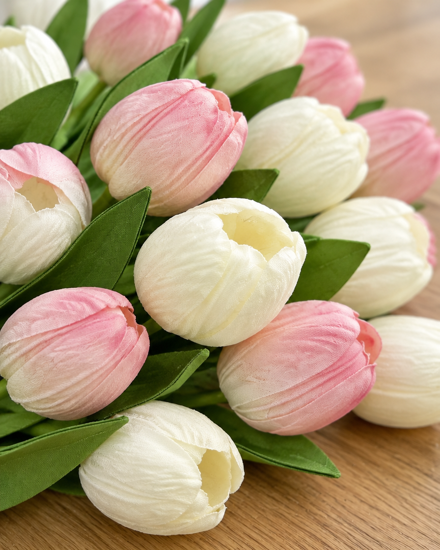 Close-up detail of the pink and white artificial tulip bouquet on an oak table