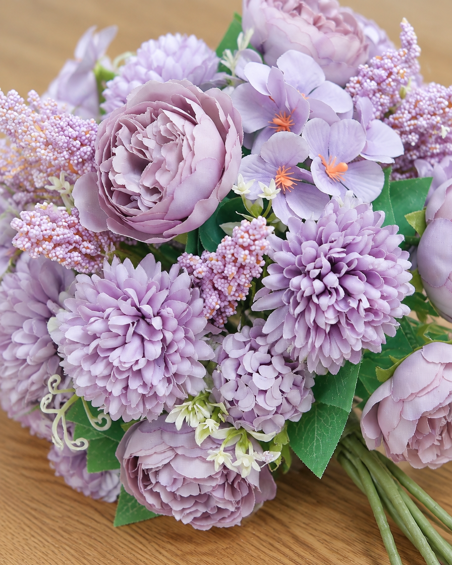 Close-up detail of the lilac artificial peony & hydrangea bouquet on an oak table