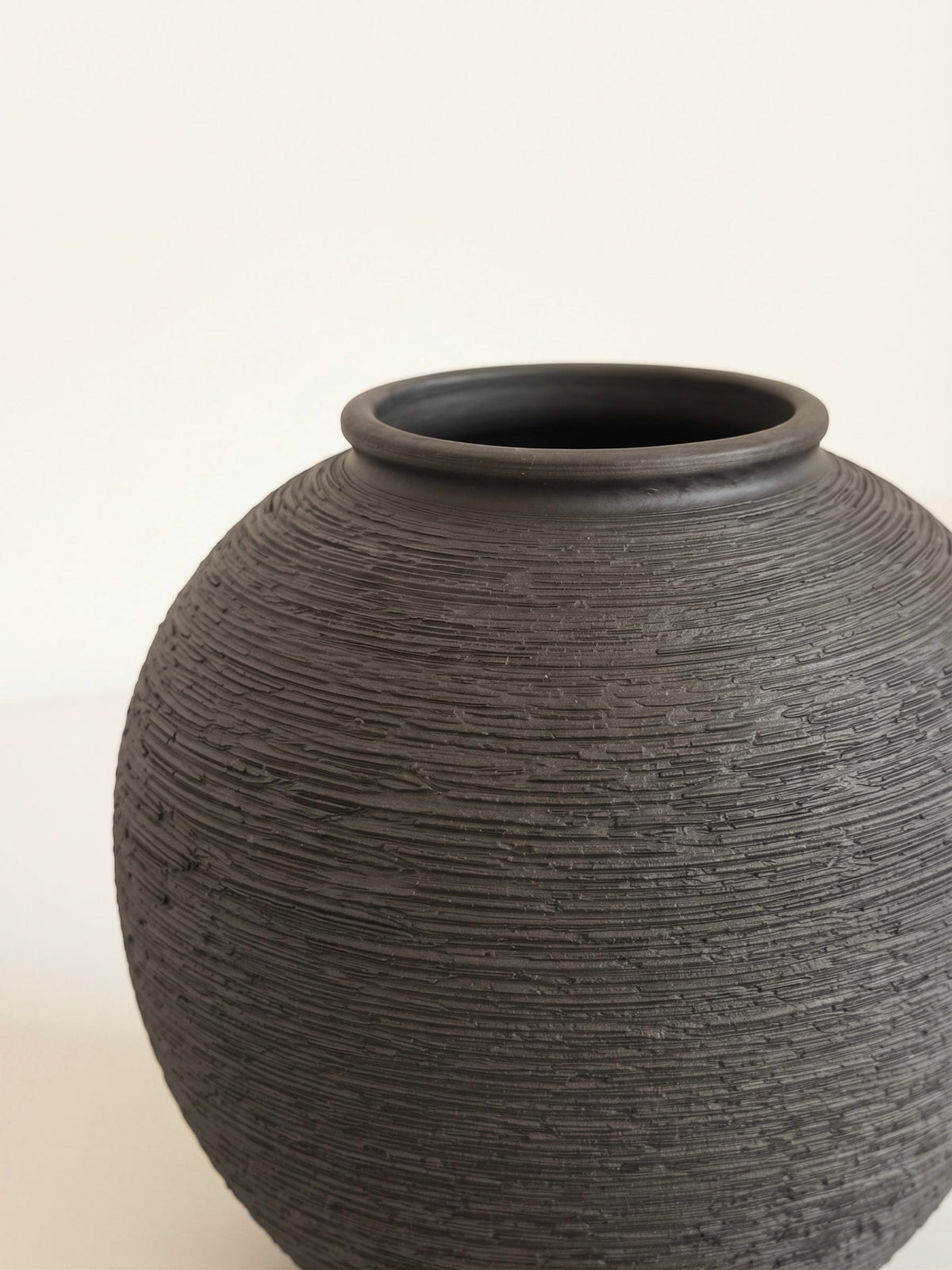 Black orb vase with linear texture styled
