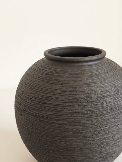 Black orb vase with linear texture styled