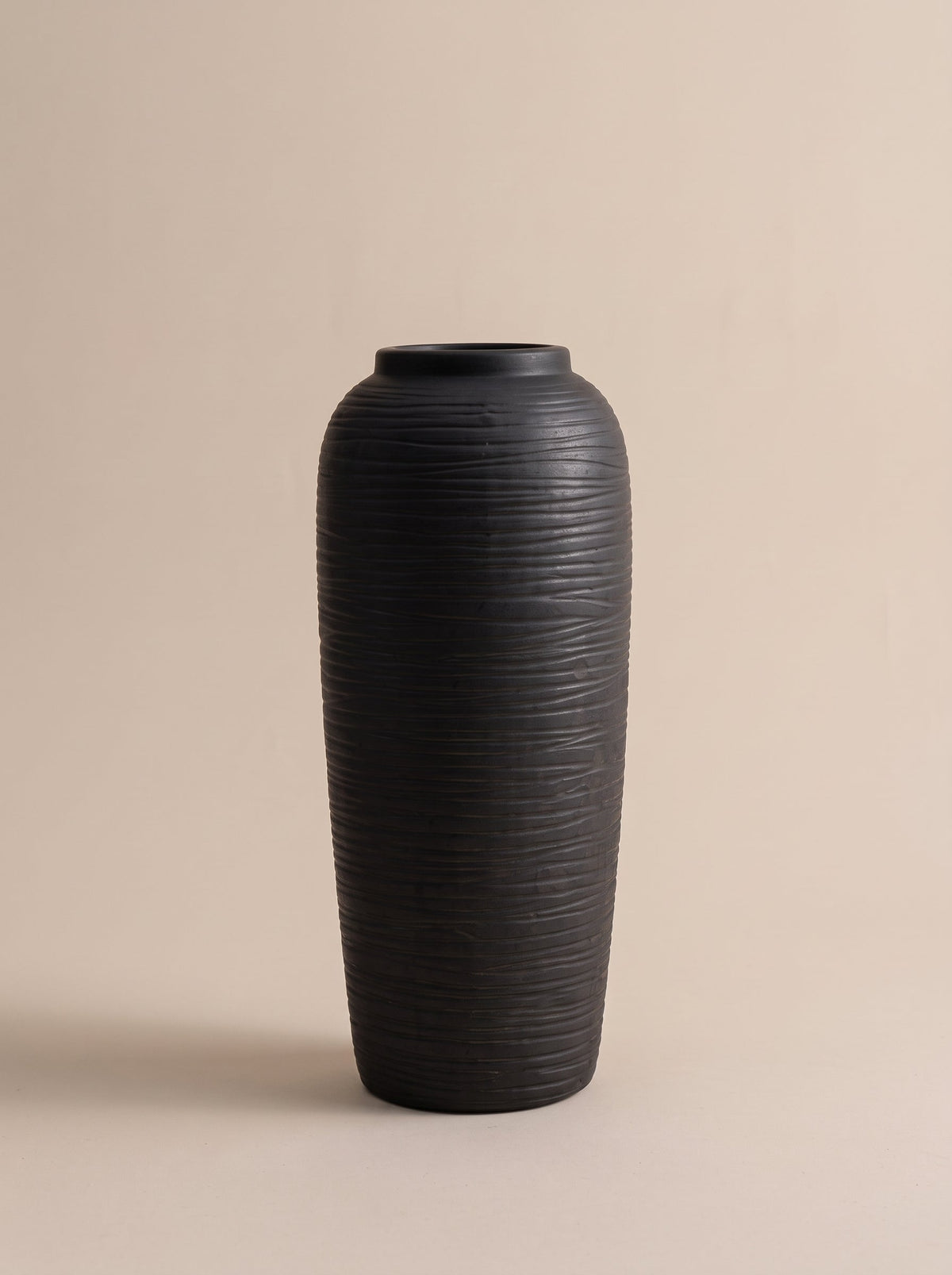 Tall matte black ceramic vase with grooved texture