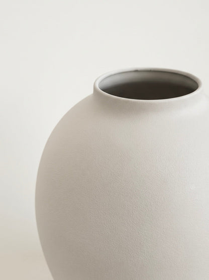 Matte white orb vase styled on a table