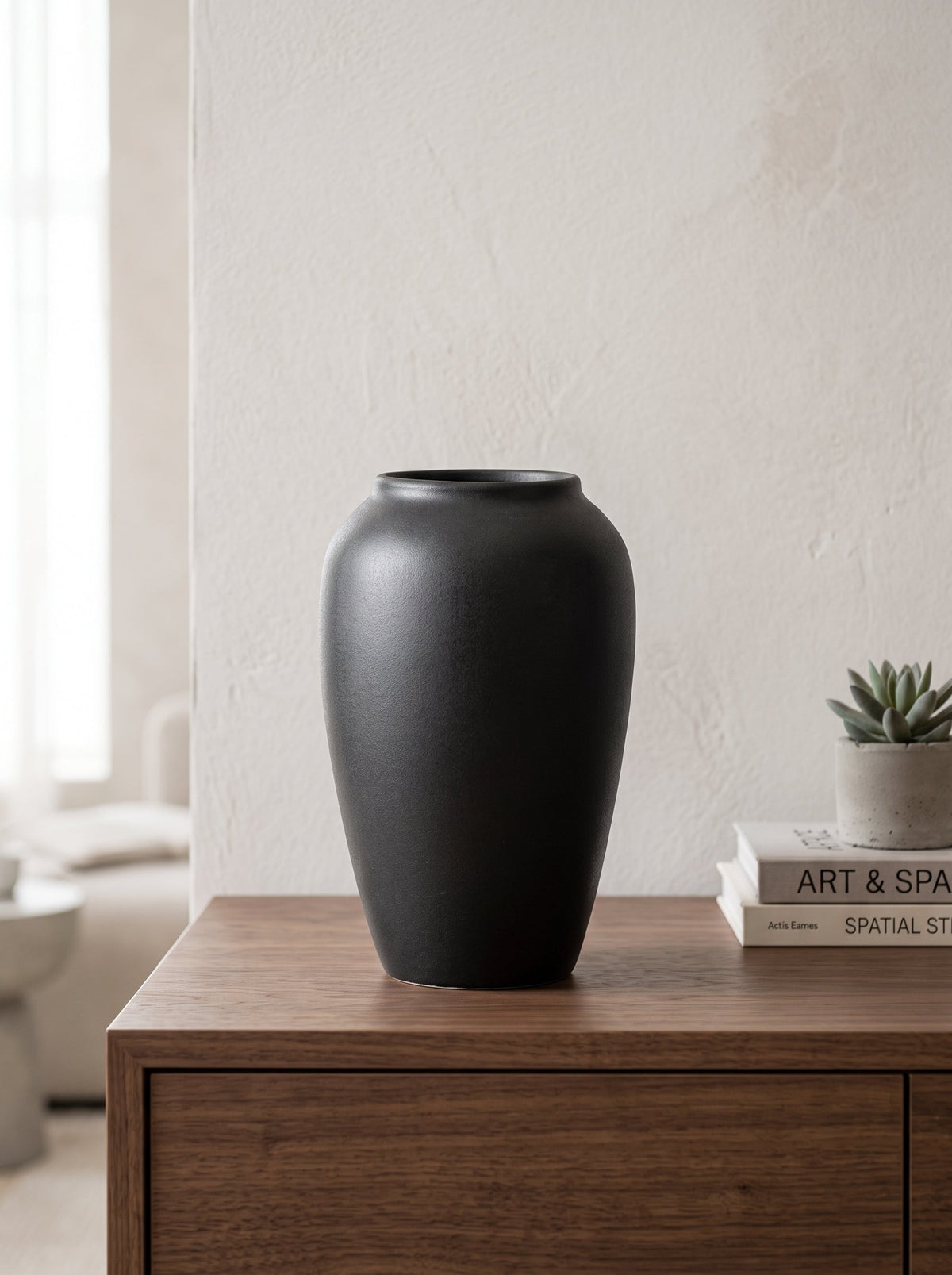 Black sculptural vase on a shelf