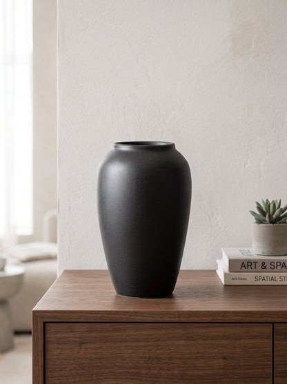 Black sculptural vase on a shelf