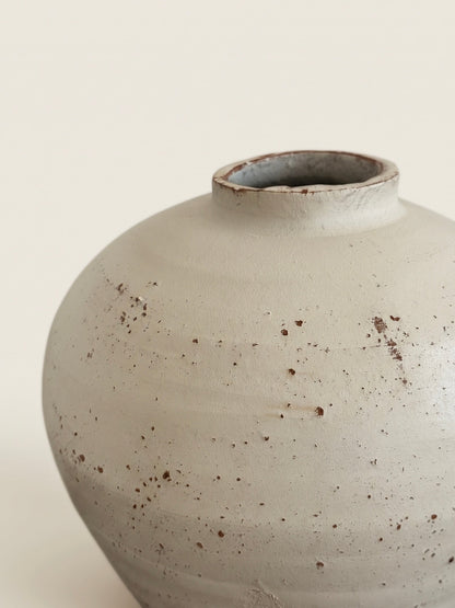 Speckled ivory urn vase styled on a shelf