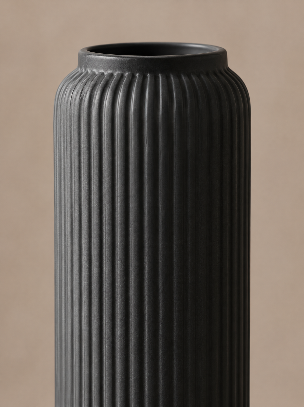 Close-up of the grooved texture and rim of a matte black ceramic vase