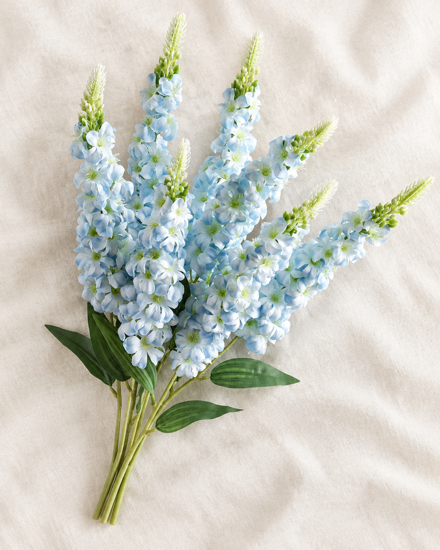 Light Blue Artificial Delphinium Flower Stems in light blue, shown alone on a linen background