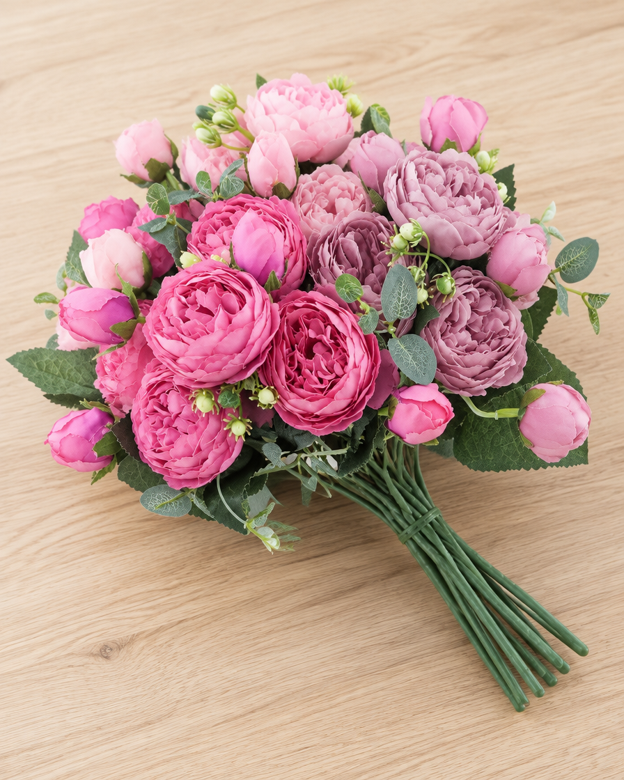 Close-up detail of the pink artificial peony bouquet on an oak table