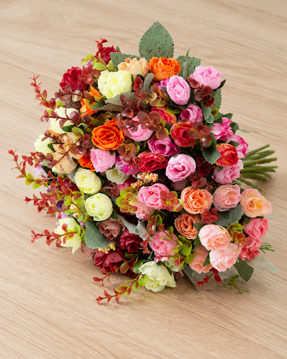 Close-up detail of the mixed red & orange artificial rose bouquet with stems on an oak table