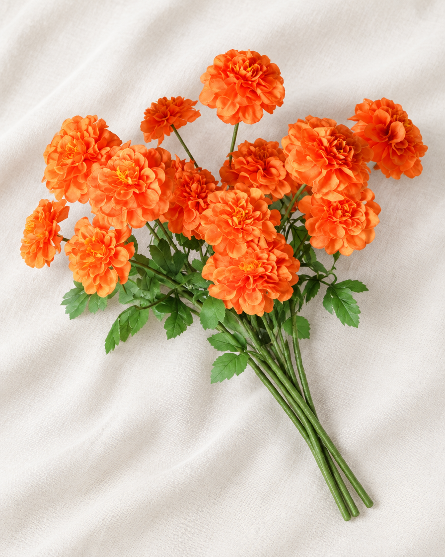 Orange Artificial Marigold Stems in orange, shown alone on a linen background