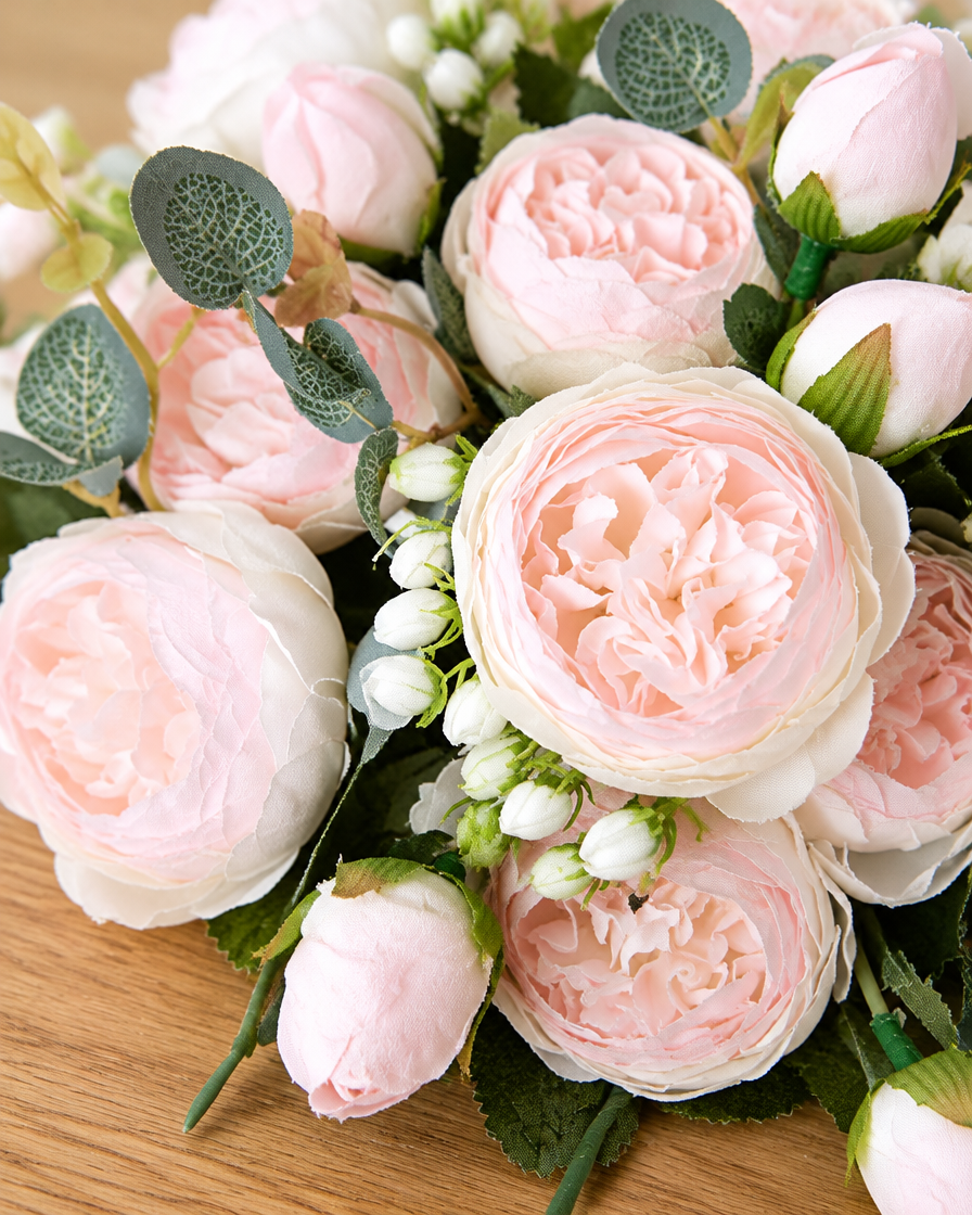Close-up detail of the blush pink artificial peony bouquet on an oak table