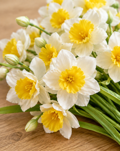 Close-up detail of the cream & yellow artificial daffodil bunch on an oak table