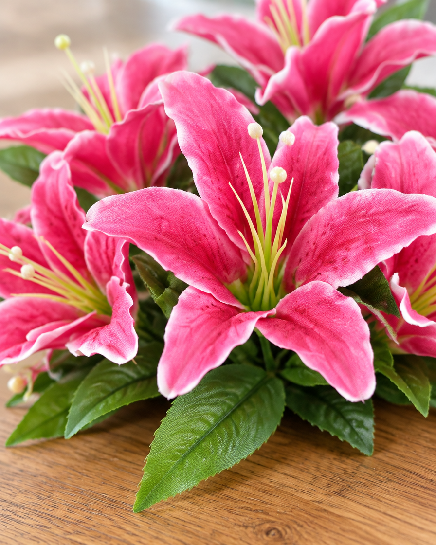 Close-up detail of the pink artificial lily bouquet on an oak table