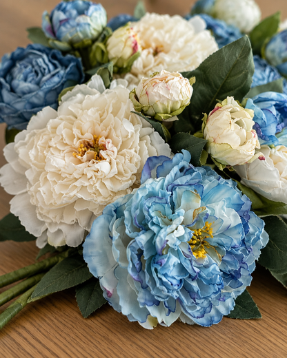 Close-up detail of the blue & cream artificial peony bouquet on an oak table