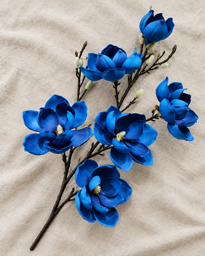Royal Blue Artificial Magnolia Branch, shown alone on a linen background