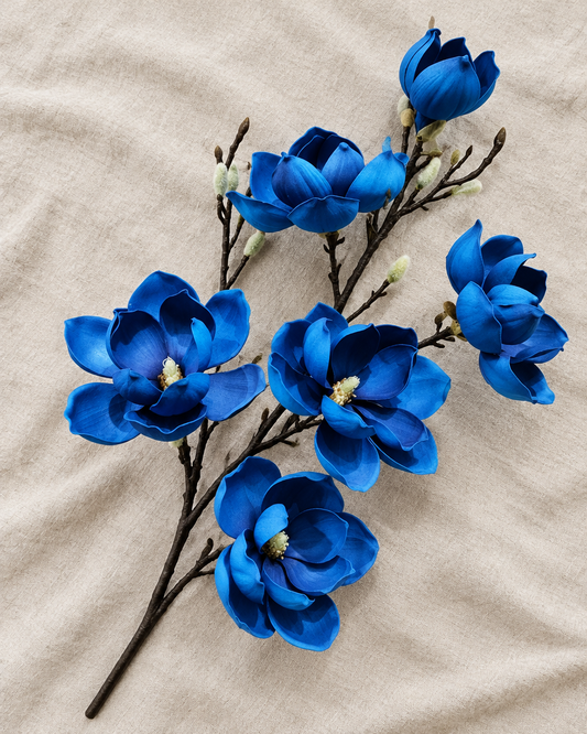 Royal Blue Artificial Magnolia Branch, shown alone on a linen background