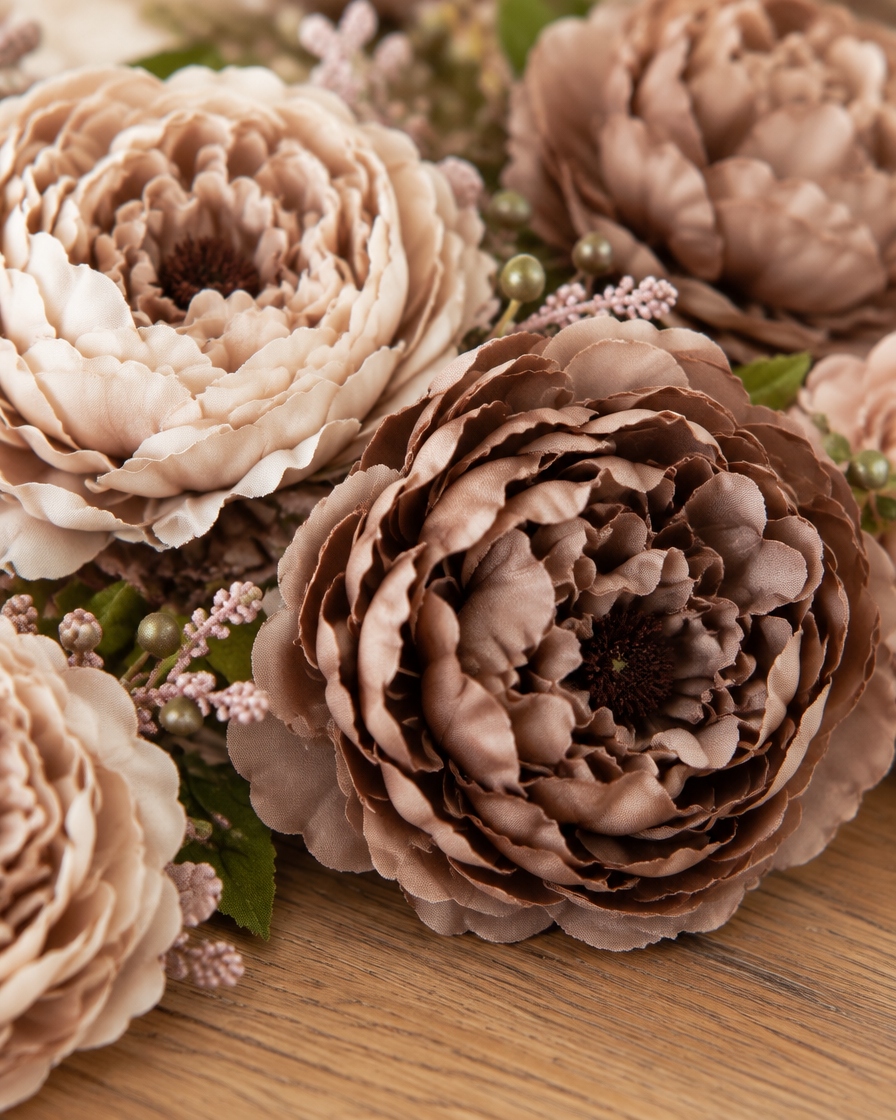 Close-up detail of the mocha brown artificial peony bouquet on an oak table