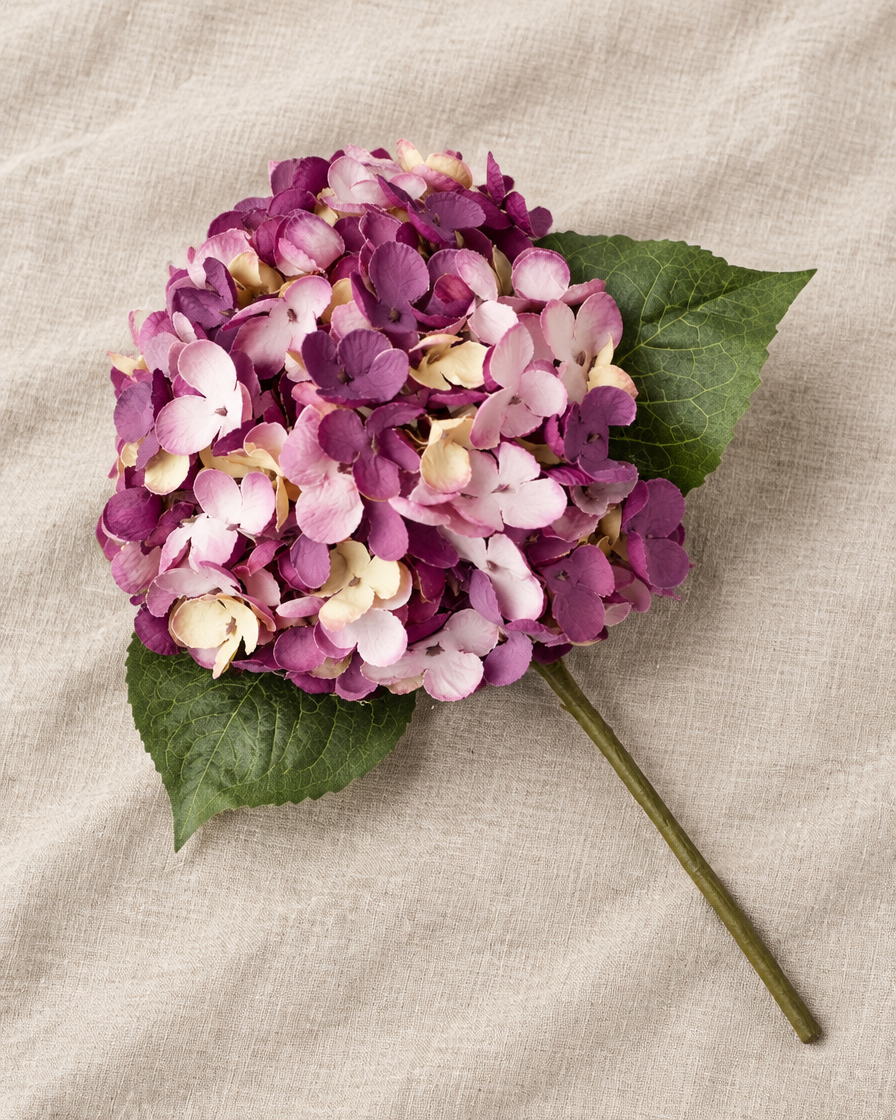 Plum Purple Artificial Hydrangea Stem, shown alone on a linen background