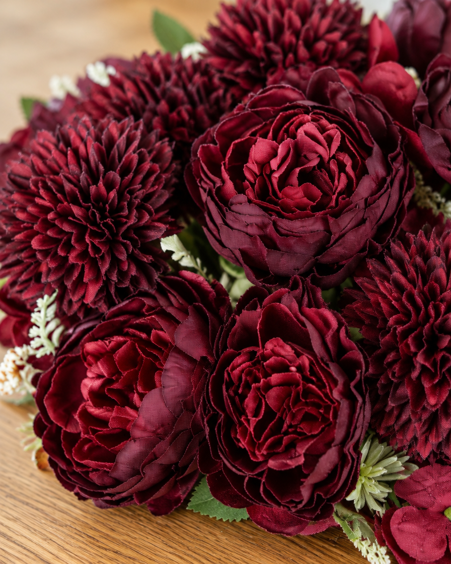 Close-up detail of the burgundy artificial peony & dahlia bouquet on an oak table
