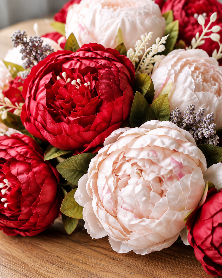 Close-up detail of the red & cream artificial peony bouquet on an oak table