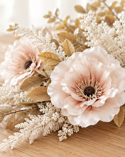 Close-up detail of the blush artificial poppy & pampas bouquet on an oak table