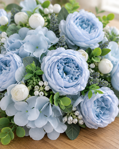 Close-up detail of the light blue artificial peony & hydrangea bouquet on an oak table