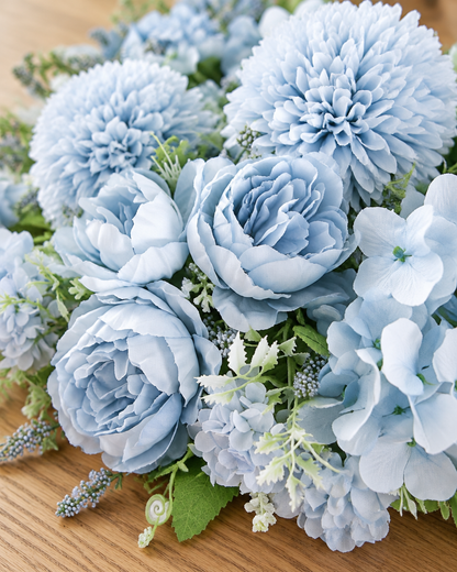 Close-up detail of the light blue artificial peony & pompom mixed bouquet on an oak table