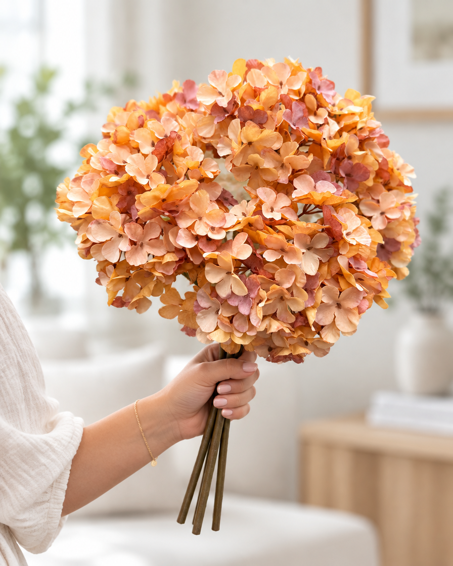 Amber Orange Artificial Hydrangea Bouquet held in a hand