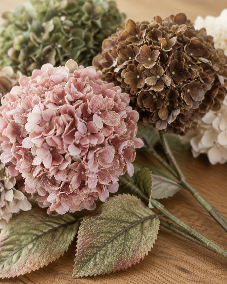 Close-up detail of the vintage multicolour artificial hydrangea bouquet on an oak table