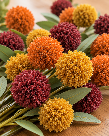 Close-up detail of the autumn artificial pom-pom flower stems on an oak table