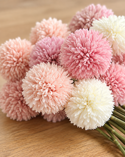 Close-up detail of the pink & cream artificial pompom ball flower stems on an oak table