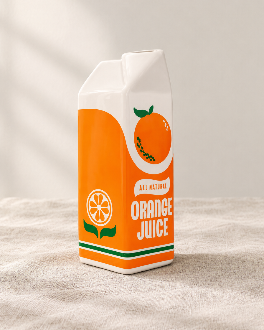 Orange Juice Carton Ceramic Vase, shown alone on a linen background