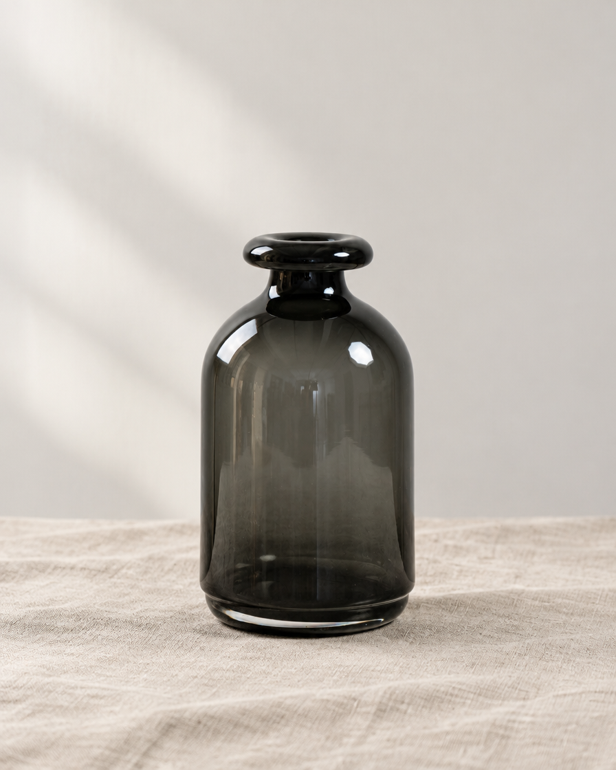Smoked Dark Grey Bottle Vase, shown alone on a linen background