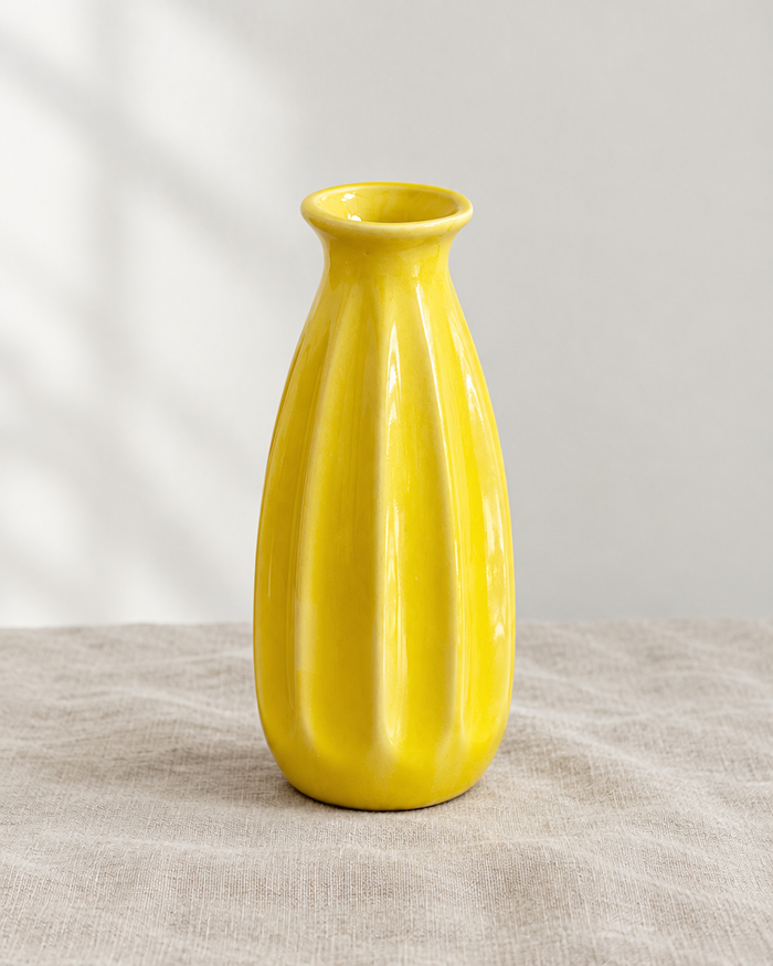 Yellow Ribbed Ceramic Bud Vase, shown alone on a linen background