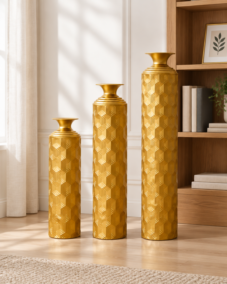 Set of 3 Gold Honeycomb-Texture Metal Floor Vases beside a bookshelf