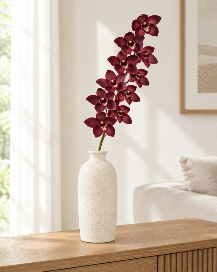 Burgundy Artificial Cymbidium Orchid Stem styled in a ceramic vase on a console table (vase sold separately)