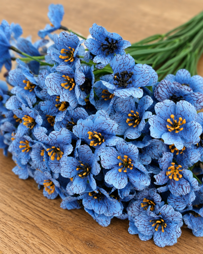 Close-up detail of the blue artificial flower bunch on an oak table